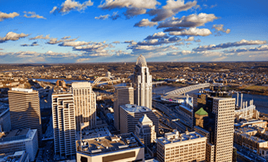 aerial view of cincinatti ohio during sunset, with the river and buildings off in the distance