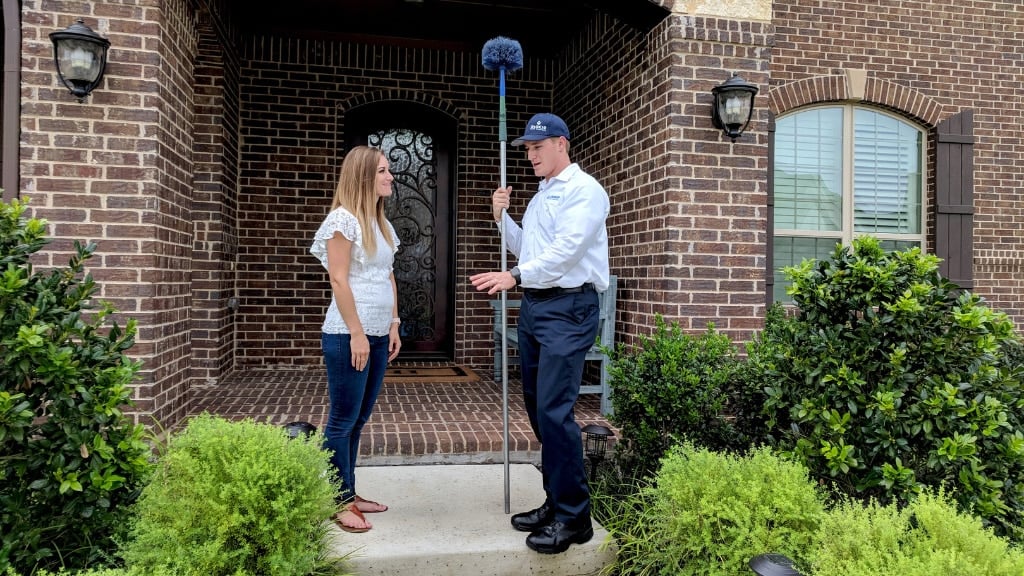 technician talking to a client about cicadas and how to deal with them in front of their home