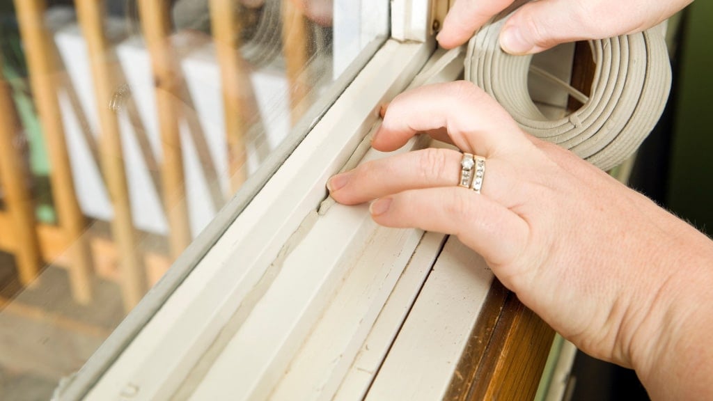 homeowner applying caulking for their window sill to prevent insects from crawling in