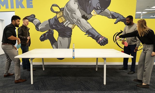 moxie pest control employees enjoying break time with a game of ping pong