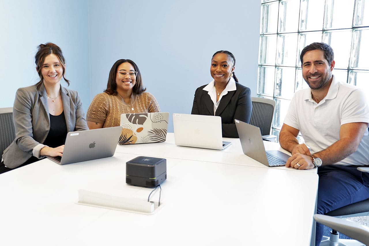 moxie pest control services employees sitting in conference room smiling at camera