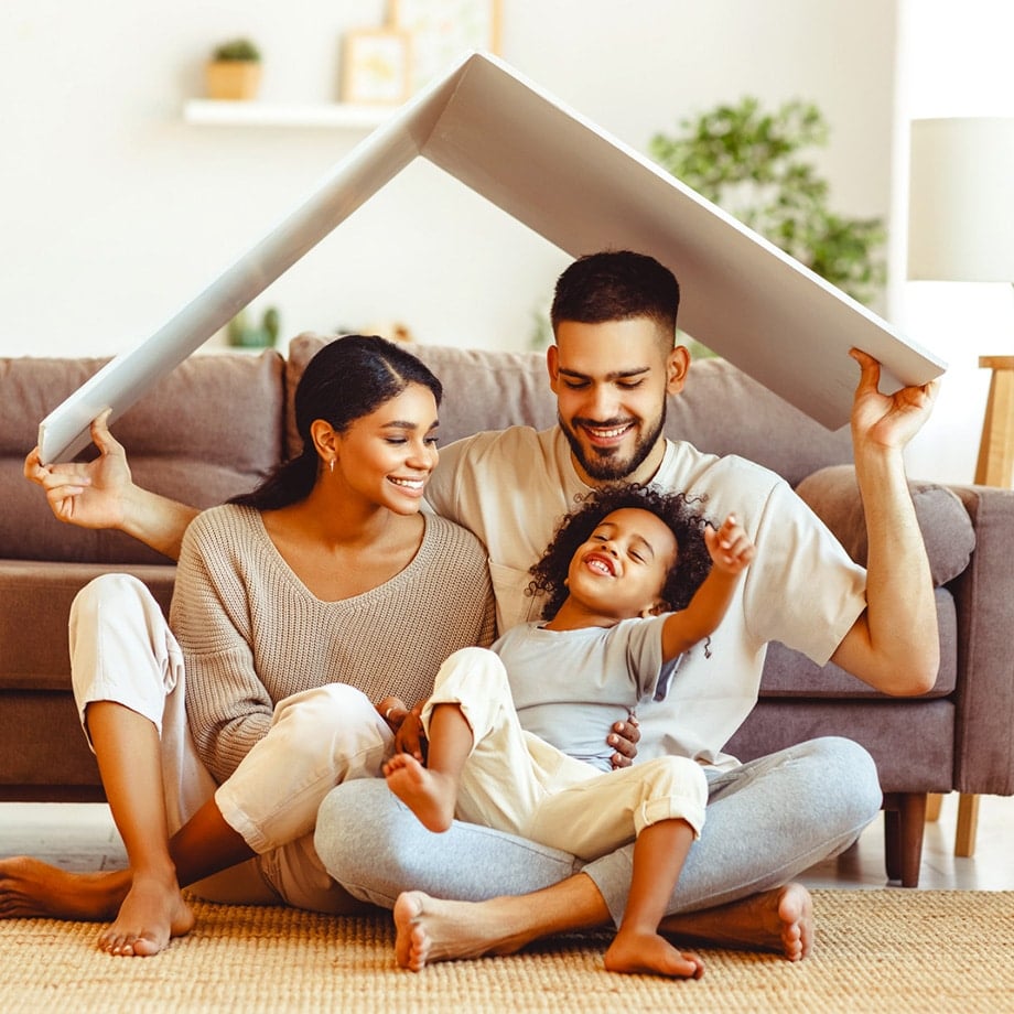 closeup of mixed family sitting on the floor in their living room playing a game laughing and smiling